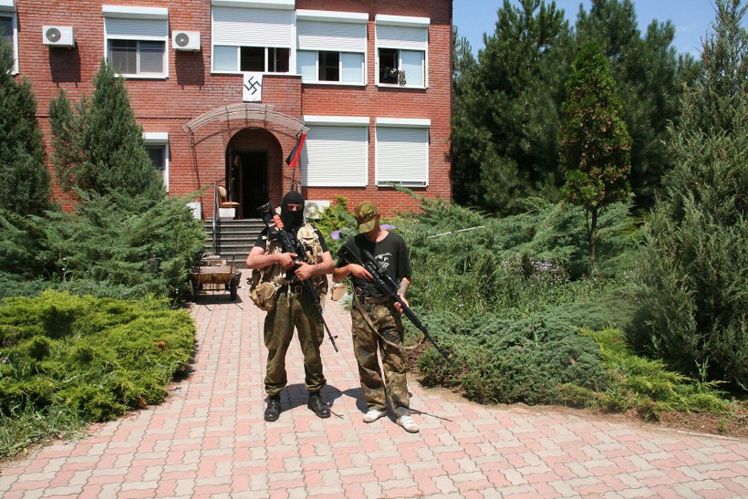 Binh sĩ tiểu đoàn Azov đứng trước ngôi nhà có gắn biểu tượng của Đức Quốc xã (Ảnh: Getty).