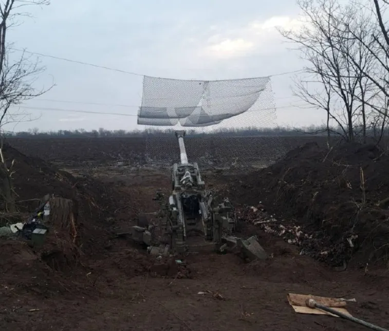 Lưới thép được quân đội Ukraine giăng phía trên khẩu pháo xe kéo để bảo vệ nó khỏi bị UAV tự sát Lancet-3 tiêu diệt (Ảnh: QQ).
