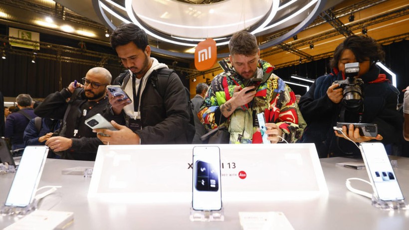 Khách tham quan chụp ảnh mẫu điện thoại di động Xiaomi 13 tại gian hàng Xiaomi trước Đại hội Thế giới Di động 2023 ở Barcelona, Tây Ban Nha, ngày 26 tháng 2/2023.