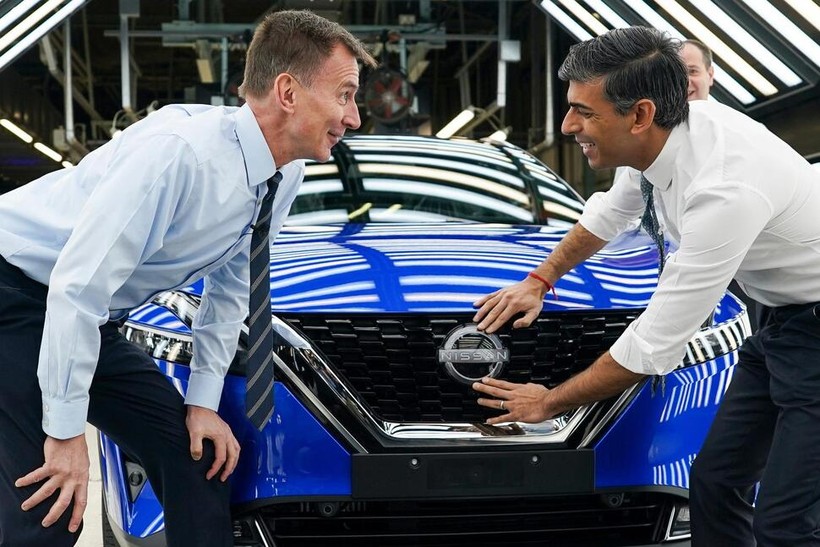 Thủ tướng Anh Rishi Sunak và Bộ trưởng Bộ Tài chính Jeremy Hunt gắn huy hiệu Nissan vào một chiếc ô tô khi đến thăm nhà máy của Nissan ở Sunderland, Anh. Ảnh AP