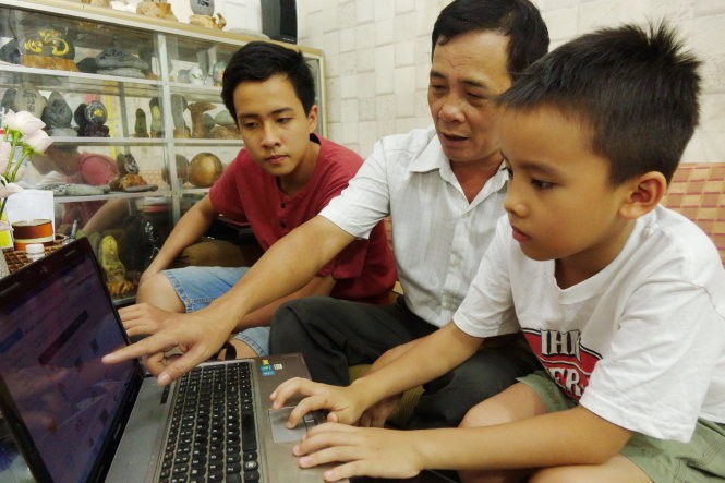 Tám năm trôi qua, con trai lớn của thầy Ninh giờ đã học lớp 9 (bìa trái). Phần mềm học chữ, tính toán giờ đây được thầy Ninh hướng dẫn tiếp cho con trai đang học tiểu học của mình - Ảnh: NHƯ HÙNG