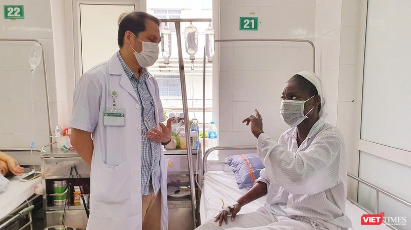 Bác sĩ Trung tâm Bệnh nhiệt đới Bệnh viện Bạch Mai trò chuyện, động viên bệnh nhân bị sốt rét ác tính trong những ngày điều trị (ảnh BV cung cấp)