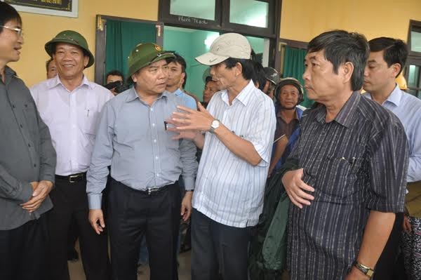 Ông Nguyễn Sự (thứ 2 từ phải qua) báo cáo Phó Thủ tướng Nguyễn Xuân Phúc công tác phòng chống lụt bão tại Hội An năm 2014
