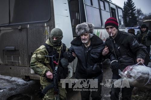 Binh lính thuộc chính phủ Ukraine sơ tán người dân khỏi khu vực chiến sự. Ảnh: AFP-TTXVN