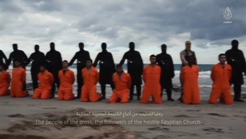 Các con tin Ai Cập quỳ trên bãi biển trước khi bị phiến quân IS chặt đầu. Ảnh: Aljazeera