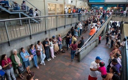 Người dân Venezuela xếp hàng chờ mua hàng hóa thiết yếu bên ngoài một siêu thị ở thủ đô Caracas.