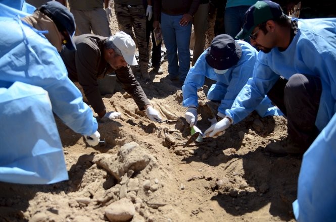 Các chuyên gia pháp y Iraq khai quật một hố chôn tập thể ở Tikrit Ảnh: Reuters