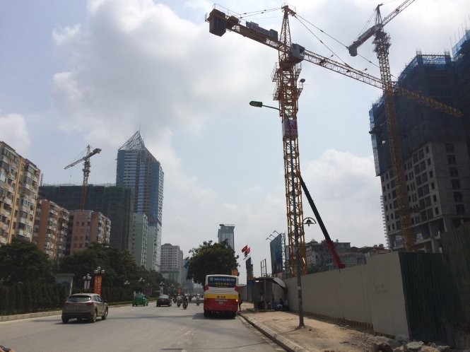 Hàng loạt cần cẩu công trường xây dựng lơ lửng đe dọa an toàn cho người đi đường trên đường Lê Văn Lương (Hà Nội) - Ảnh: Lâm Hoài