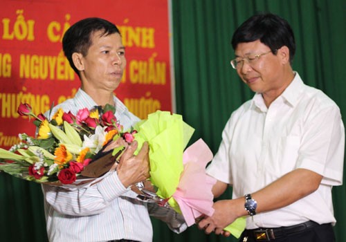 Phó Chánh toà phúc thẩm TAND Tối cao Ngô Hồng Phúc tặng hoa ông Nguyễn Thanh Chấn sau khi đọc bản xin lỗi.