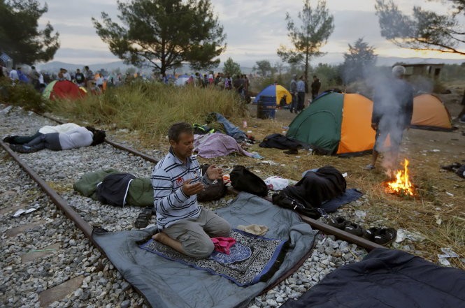 Người nhập cư Syria nghỉ chân ở biên giới Hi Lạp - Macedonia - Ảnh: Reuters