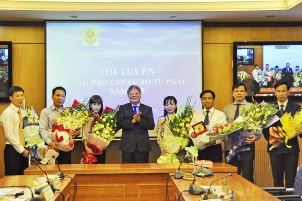 Bộ trưởng Bộ Tư pháp Hà Hùng Cường tặng hoa chúc mừng các ứng viên trúng tuyển. Ảnh: Cổng thông tin Bộ Tư pháp
