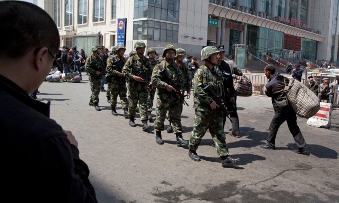 Cảnh sát vũ trang Trung Quốc tuần tra ở Tân Cương - Ảnh: Guardian