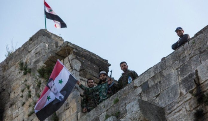 Cờ Syria được các binh sĩ gương cao trên tòa nhà mới chiếm lại