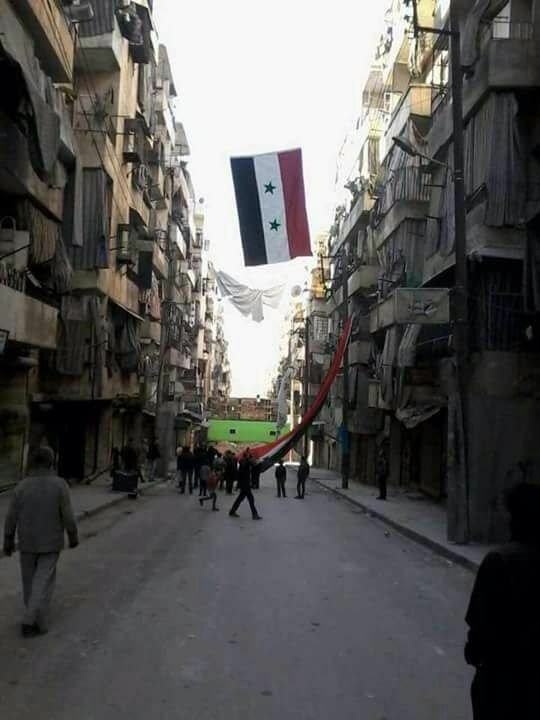 Người dân Syria ở khu các quận phía đông Aleppo đang treo một lá cờ khổng lồ để ăn mừng chiến thắng ở Aleppo