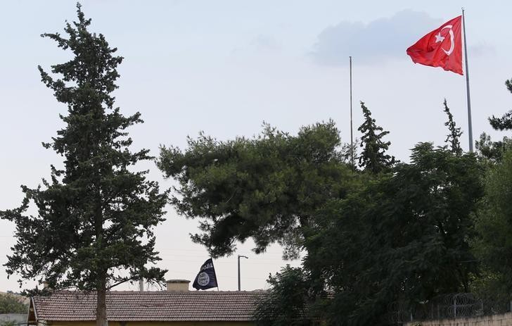 Lá cờ Thổ Nhĩ Kỳ trên khu vực cửa khẩu biên giới Karkamış, phía sau là cờ của IS, cắm trên cơ quan hải quan cửa khẩu Jarablus Syria, ngay sát cửa khẩu Karkamış, tỉnh Gaziantep thuộc Thổ Nhĩ Kỳ ngày 01.08.2015. Reuters / Murad Sezer