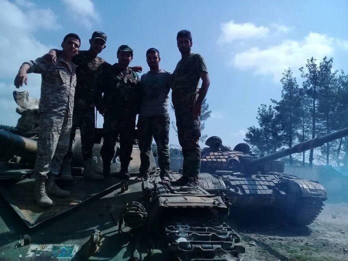 Binh sĩ lực lượng vũ trang địa phương NDF trên xe tăng quân đội Syria