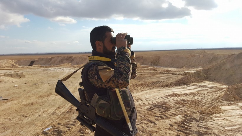 Một sĩ quan quân đội Syria đang quan sát chiến trường tỉnh Homs, Hama