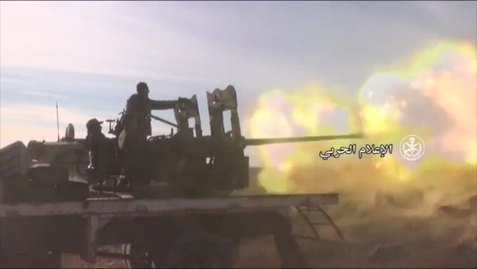 Xe pháo binh quân đội Syria khai hỏa chống phiến quân - ảnh minh họa Masdar News