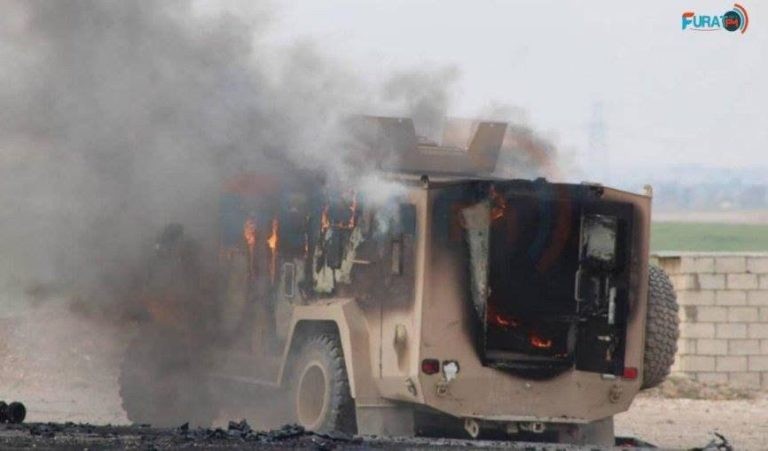 Xe cơ giới bọc thép của liên minh quân sự quốc tế do Mỹ dẫn đầu bị đánh bom khủng bố. Ảnh: Pura.