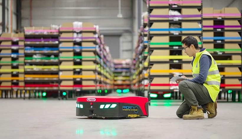 Một nhân viên của Mushiny kiểm tra một robot di động tự động tại một nhà kho ở Australia. Ảnh China Daily.