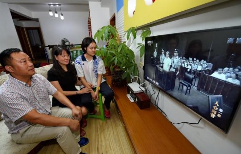 Người dân Trung Quốc xem xét xử các vụ án tham nhũng qua ti vi. Ảnh: Cankao