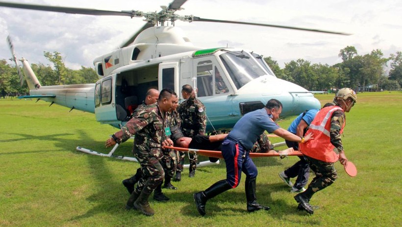 Binh lính đang cáng một nhân viên an ninh bị thương trong vụ đánh bom ở thành phố Marawi.