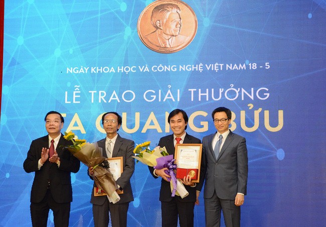 Phó Thủ tướng Vũ Đức Đam và Bộ trưởng Bộ KH&CN Chu Ngọc Anh tặng giấy chứng nhận và hoa chúc mừng hai nhà khoa học nhận Giải thưởng. (Ảnh: Dân trí)

