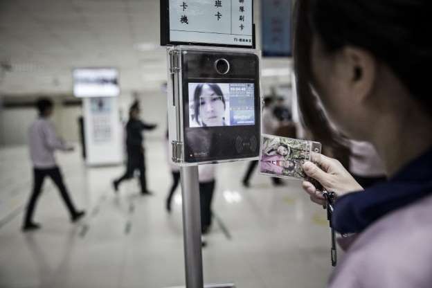 Một nhân viên đang sử dụng thiết bị nhận diện khuôn mặt khi "check in" để vào khu vực dây chuyền lắp ráp