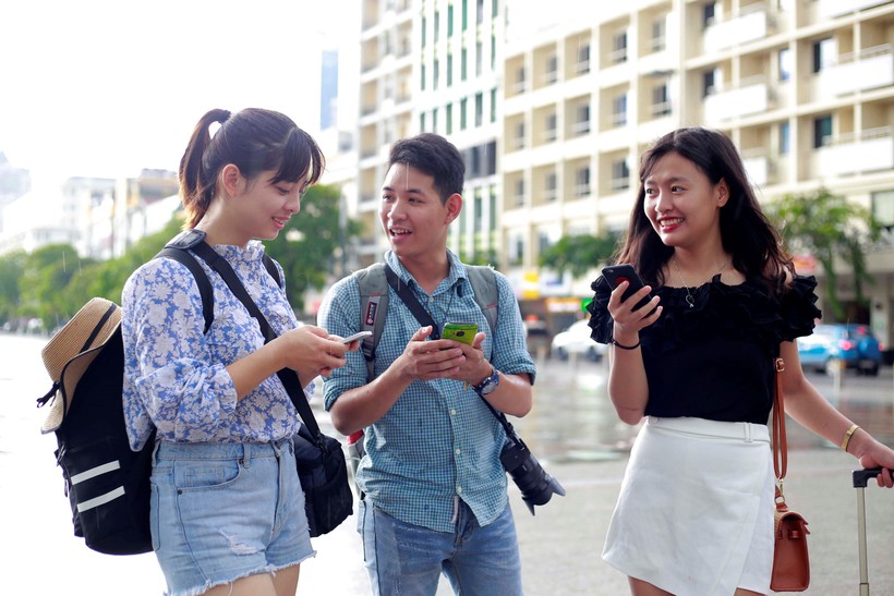 Các bạn trẻ sử dụng wifi miễn phí trên phố đi bộ Nguyễn Huệ. Nguồn Thanh Niên
