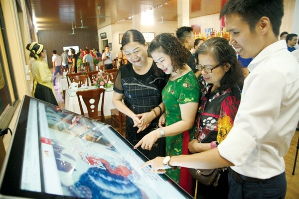 Du khách trải nghiệm ứng dụng du lịch thông minh tại Trung tâm thông tin du lịch Bát Tràng (Hà Nội)