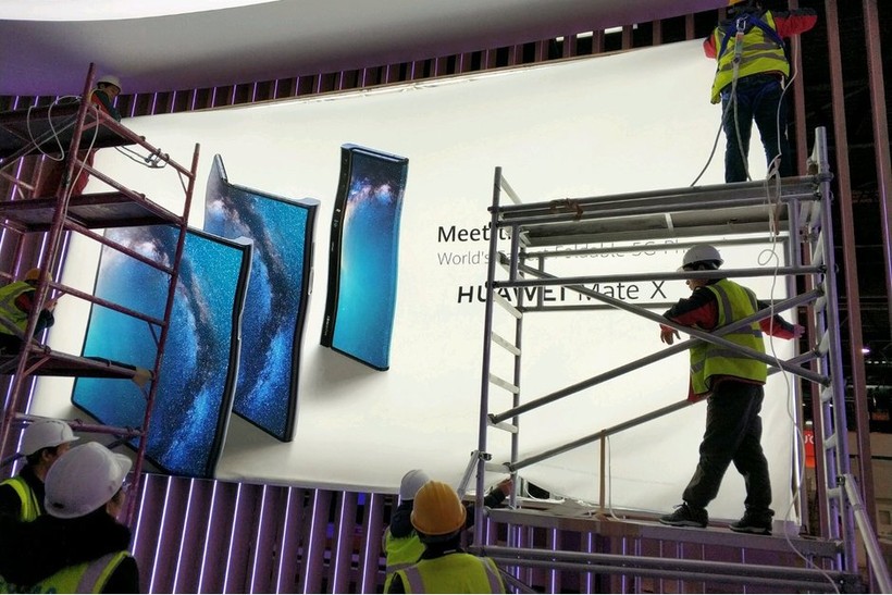Các công nhân đang thi công poster quảng cáo điện thoại Huawei Mate X (ảnh: Phone Arena)