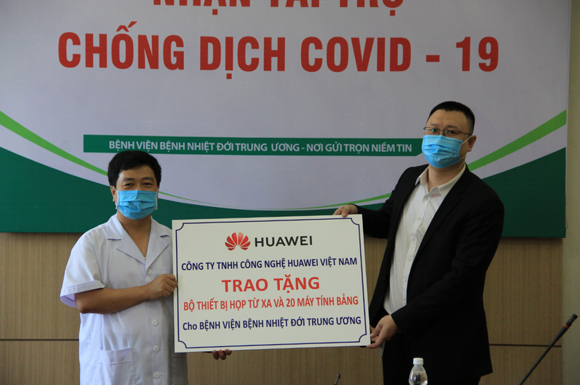 Ông Ma Yunhui, Phó tổng giám đốc Công ty TNHH Công nghệ Huawei Việt Nam (phải), đại diện công ty, trao tặng Bộ thiết bị giải pháp hội nghị truyền hình và 20 máy tính bảng cho ông Lê Văn Dụng, Phó Giám đốc Bệnh viện Bệnh Nhiệt đới Trung ương