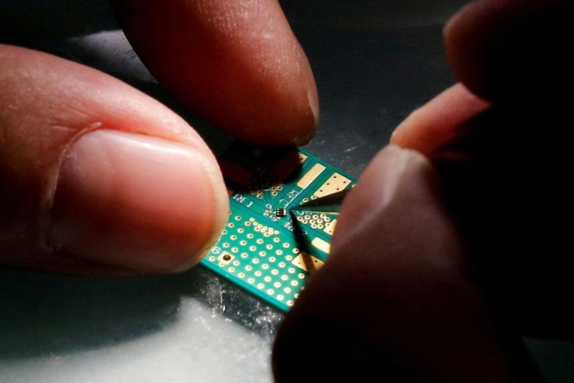 Một kỹ sư đặt chip bán dẫn lên bo mạch trong quá trình nghiên cứu thiết kế và phát triển sản phẩm bán dẫn tại Trung tâm Thanh Hoa Unigroup ở Bắc Kinh, Trung Quốc, ngày 29 tháng 2 năm 2016 (ảnh Reuters)