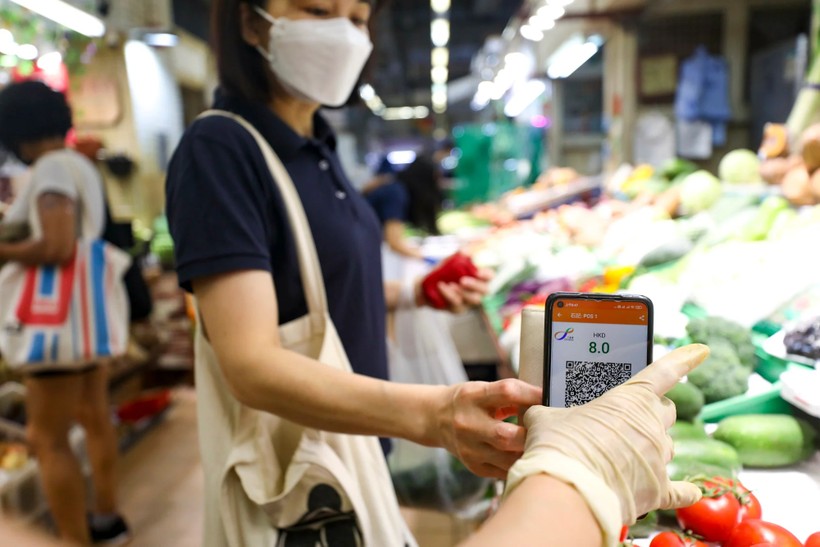 Một người phụ nữ sử dụng app thanh toán Octopus của mình để mua hàng tại chợ Sai Ying Pun (ảnh: Xiaomei Chen)