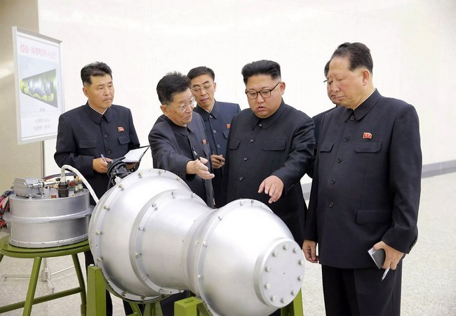 Nhà lãnh đạo Triều Tiên Kim Jong Un đứng trước một thiết bị được cho là đầu đạn hạt nhân thu nhỏ (Ảnh AP)