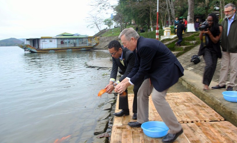 Đại sứ Mỹ Ted Osius và người bạn đời Clayton Bond cùng thực hiện nghi lễ thả cá chép trên sông Hương để tiễn đưa ông Công ông Táo về trời - Ảnh: Nguyên Linh