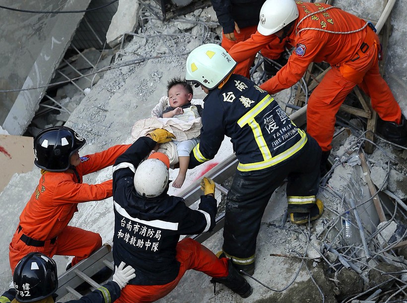 Lực lượng cứu hộ giải thoát cho một đứa bé trong khu chung cư 17 tầng sau trận động đất ở Đại Nam (Đài Loan) hôm 6.2 - Ảnh: AFP