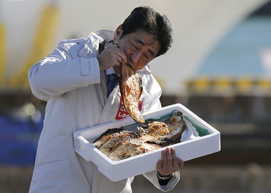 Ông Abe không ngần ngại ăn cá nướng tại tỉnh Fukushima. Ảnh: Reuters