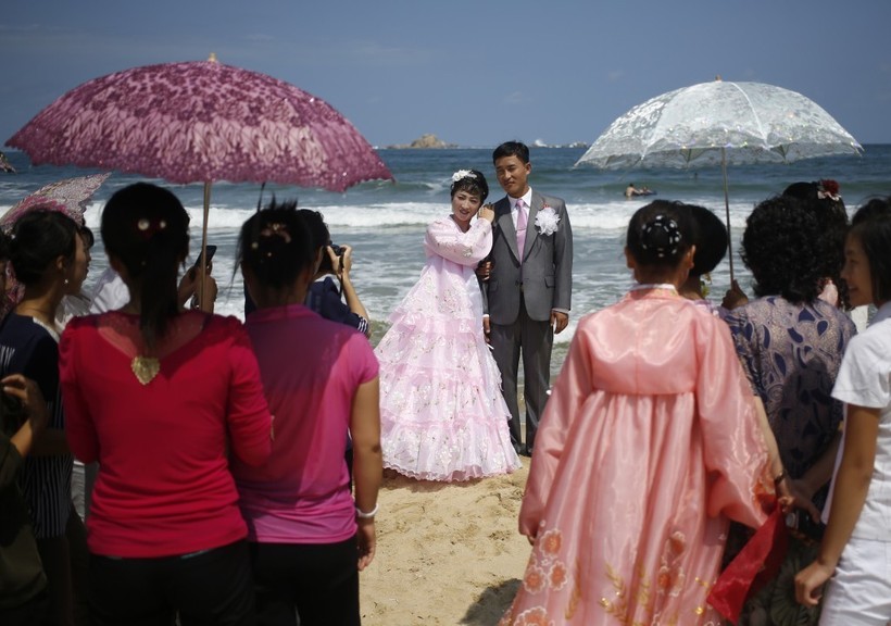 Cặp đôi mới cưới chụp ảnh trên bãi biển Sijung Ho trước sự chứng kiến của họ hàng và bạn bè.