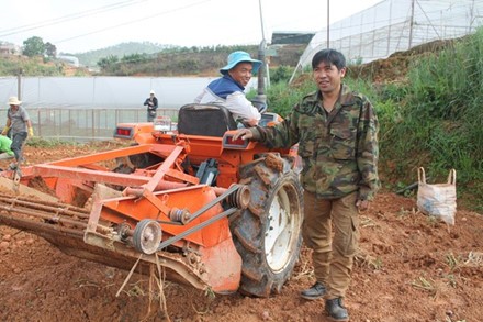 Anh Phạm Minh Thành đứng kế máy đào khoai tây đa năng tự tay anh sáng chế.