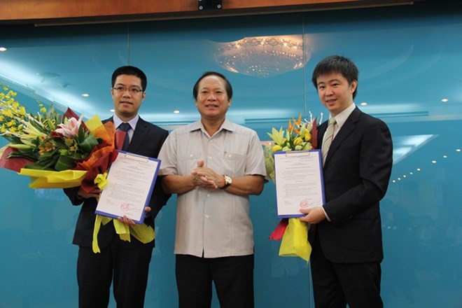 Bộ trưởng Trương Minh Tuấn trao quyết định bổ nhiệm cho ông Nguyễn Thành Chung (trái) và ông Bùi Hoàng Phương (phải). 