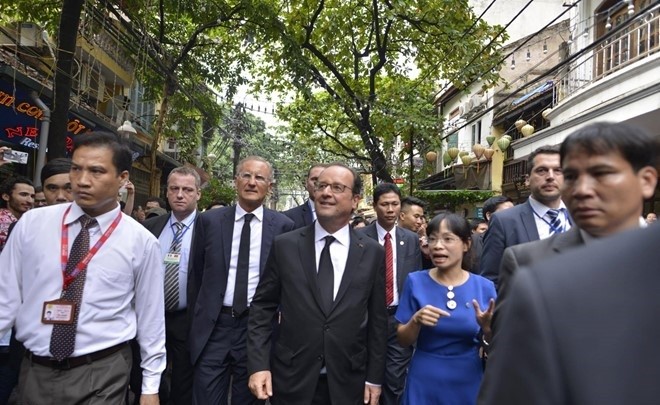 Tổng thống Pháp hòa mình vào dòng người đông đúc đi thăm khu 36 phố phường ở Hà Nội. 