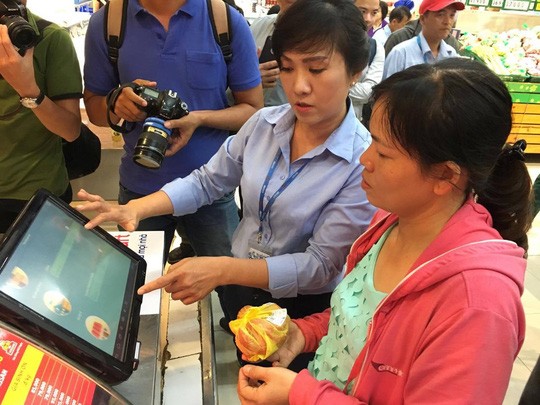 Nhân viên Co.opmart Foodcosa Quang Trung (Gò Vấp) hướng dẫn khách hàng cách kiểm tra nguồn gốc thịt heo bằng máy soi đặt tại siêu thị