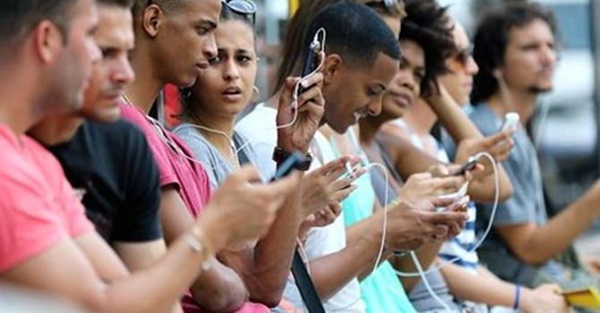 Người dân Cuba dùng điện thoại di động tại Havana. Ảnh: CNBC.