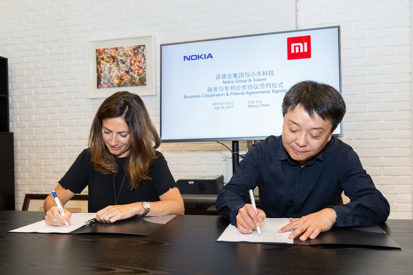 Trưởng phòng Pháp chế của Nokia - bà Maria Varsellona ký thỏa thuận hợp tác với ông Wang Xiang, Phó Chủ tịch Cấp cao của Xiaomi.