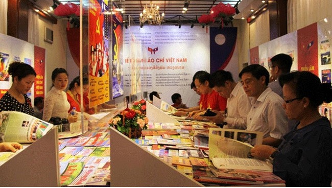 Công chúng Việt, Lào xem các ấn phẩm trưng bày tại một triển lãm báo chí được tổ chức gần đây. Ảnh minh hoạ: Báo Nhân dân.
