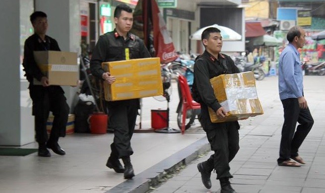 Khám xét chuỗi cửa hàng Nhật Cường, cảnh sát thu giữ hàng nghìn điện thoại, tài liệu liên quan. Ảnh: Hoàng Lam.