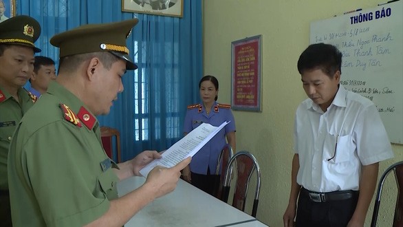 Ông Trần Xuân Yến, Phó Giám đốc Sở GD-ĐT tỉnh Sơn La (áo trắng), nghe tống đạt quyết định khởi tố bị can.