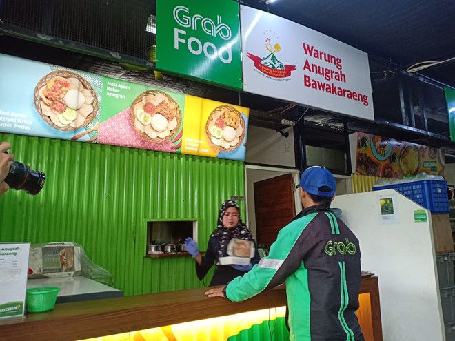 Tài xế GrabFood tới nhận đồ ăn ở quầy hàng tại GrabKitchen (ảnh chụp tại Indonesia).