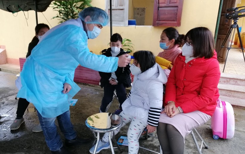 Cán bộ y tế tỉnh Lạng Sơn kiểm tra sức khỏe ban đầu đối với các công dân Việt Nam trở về từ Trung Quốc trước khi tiếp nhận vào Trung đoàn 123. Ảnh: VGP